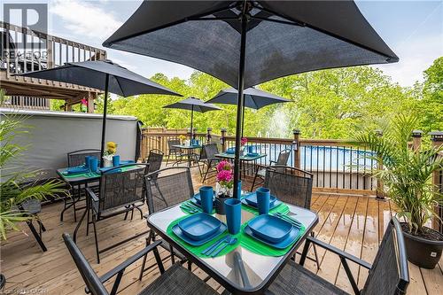 Multi-level wood deck featuring an above-ground pool, a covered hot tub, and a privacy railing with decorative post caps - 9 Fleming Crescent, Caledonia, ON - Outdoor With Deck Patio Veranda With Exterior