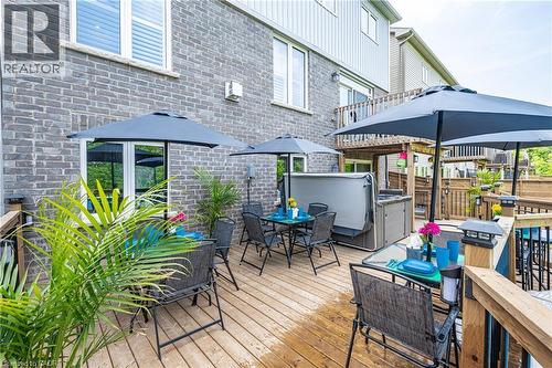 Expansive multi-level wood deck featuring a built-in hot tub, multiple shaded dining areas, and integrated lighting on railing posts - 9 Fleming Crescent, Caledonia, ON - Outdoor With Deck Patio Veranda
