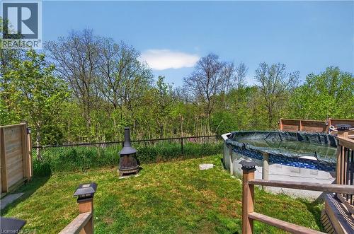 Grassed backyard featuring an above-ground pool, a chiminea, and mature trees bordering the property - 9 Fleming Crescent, Caledonia, ON - Outdoor