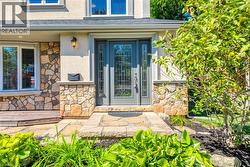 Stone facade detailing framing the entryway, featuring a prominent transom and sidelight entry door - 
