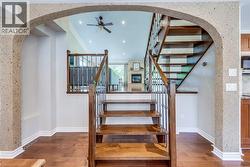 Interior staircase featuring wood treads and risers, iron balusters, and a wood handrail - 