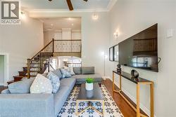 Two-story living area with hardwood flooring and a ceiling fan - 