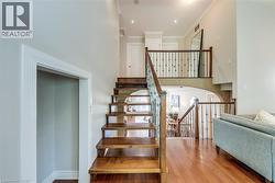 Open-tread staircase featuring wood steps, wrought iron spindles, and wood handrails - 
