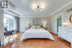 Spacious room featuring wood-finish flooring and a large arched window - 