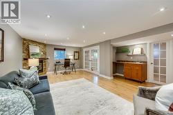Spacious living area featuring light wood-finish flooring and recessed lighting - 