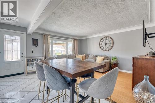 Open-concept living area featuring a prominent wood-finish counter-height table, light gray wall paint, and white trim - 151 Winchester Boulevard, Hamilton, ON - Indoor Photo Showing Dining Room