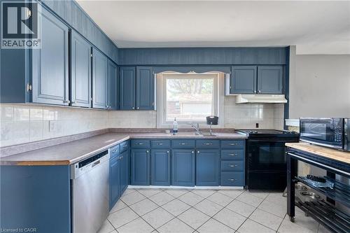 Kitchen featuring blue cabinetry, light tile backsplash, and composite countertops - 151 Winchester Boulevard, Hamilton, ON - Indoor Photo Showing Kitchen