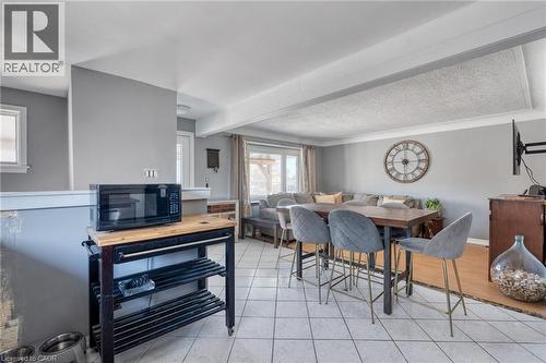 Open-concept living area featuring light gray walls, white trim, and a combination of tiled and wood-finish flooring - 151 Winchester Boulevard, Hamilton, ON - Indoor Photo Showing Dining Room