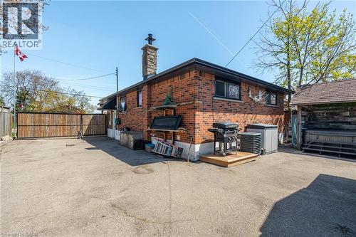 Brick exterior with a stone chimney and dark-framed windows - 151 Winchester Boulevard, Hamilton, ON - Outdoor With Exterior