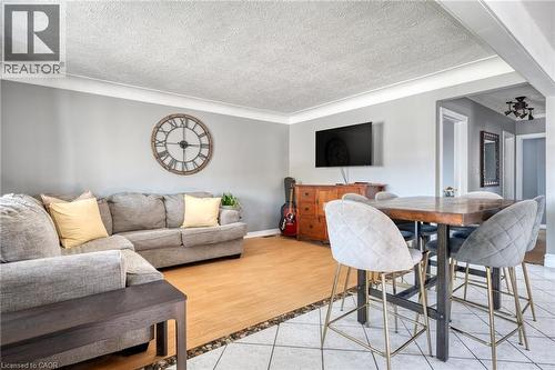 Open-concept room featuring light wood-finish flooring and tile flooring, crown molding, and neutral wall paint - 151 Winchester Boulevard, Hamilton, ON - Indoor