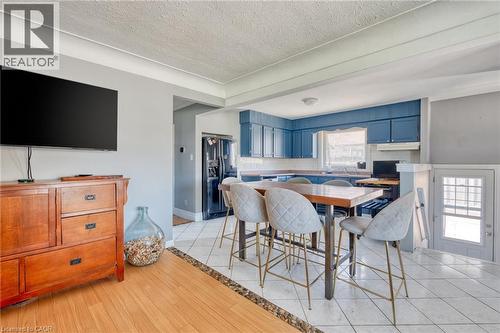 Open-concept kitchen with blue cabinetry and white tile flooring - 151 Winchester Boulevard, Hamilton, ON - Indoor Photo Showing Dining Room
