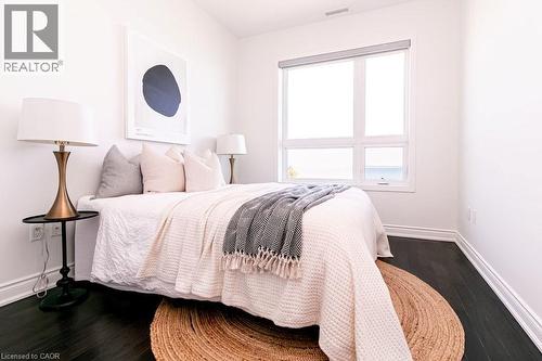 Bright interior featuring dark wood-finish flooring and a large window - 101 Shoreview Place Unit# 631, Stoney Creek, ON - Indoor Photo Showing Bedroom