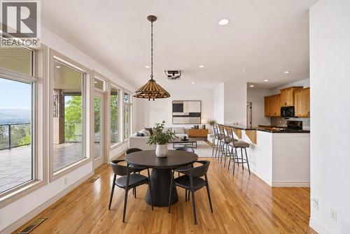 breakfast table and living room furniture are virtually staged - 448 Viewcrest Road, Kelowna, BC - Indoor Photo Showing Dining Room