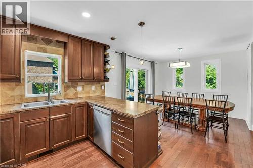 Kitchen featuring wood-finish cabinetry, stainless steel dishwasher, and a double basin sink - 25 Park Street E, Hamilton, ON - Indoor