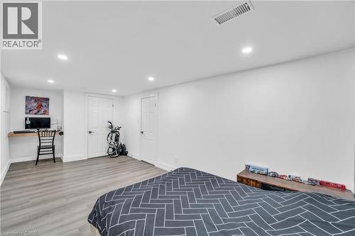 Spacious room featuring wood-finish flooring, recessed lighting, and white paneled doors - 25 Park Street E, Hamilton, ON - Indoor