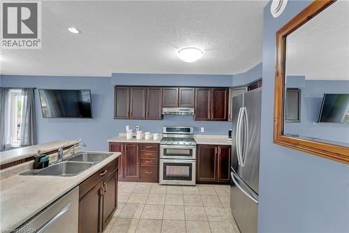 Kitchen featuring wood-finish cabinetry, stainless steel appliances, and a double basin sink - 139 Ferris Drive, Wellesley, ON - Indoor Photo Showing Kitchen With Stainless Steel Kitchen With Double Sink