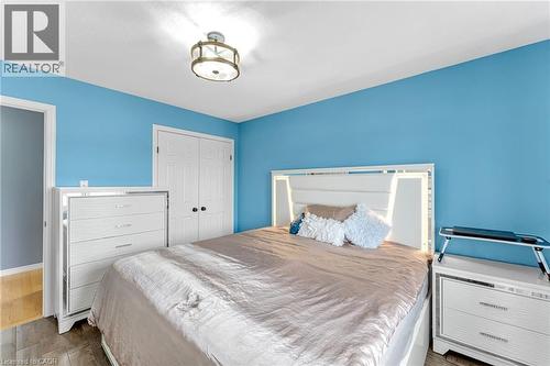 Room featuring light blue walls, wood-finish flooring, a white ceiling, and a flush-mount ceiling light fixture - 139 Ferris Drive, Wellesley, ON - Indoor Photo Showing Bedroom