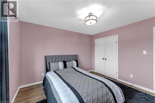 Bedroom with wood-finish flooring, light purple wall paint, and white trim - 139 Ferris Drive, Wellesley, ON - Indoor Photo Showing Bedroom