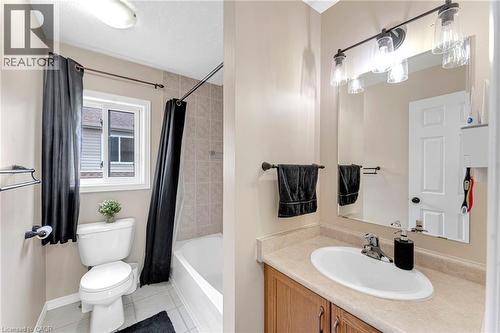 Full bathroom featuring an integrated bathtub and shower with tiled surround, a white window, and a light wood-finish vanity with an integrated sink and light-toned countertop - 139 Ferris Drive, Wellesley, ON - Indoor Photo Showing Bathroom