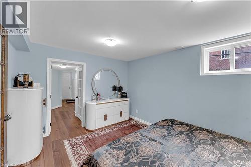 Bedroom featuring wood-finish flooring, light blue walls, and a white trim window - 139 Ferris Drive, Wellesley, ON - Indoor Photo Showing Bedroom