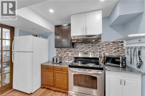 Kitchen space featuring a tile backsplash, stainless steel range with overhead ventilation, and light blue wall paint - 139 Ferris Drive, Wellesley, ON - Indoor Photo Showing Kitchen