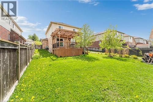 Spacious green lawn featuring a wooden privacy fence and a rear deck with a pergola structure - 139 Ferris Drive, Wellesley, ON - Outdoor With Deck Patio Veranda