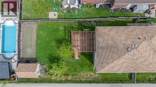 Expansive property featuring a rectangular inground swimming pool with integrated steps, a surrounding paved patio, a wooden pergola, and a storage shed with a shingled roof - 139 Ferris Drive, Wellesley, ON - Outdoor