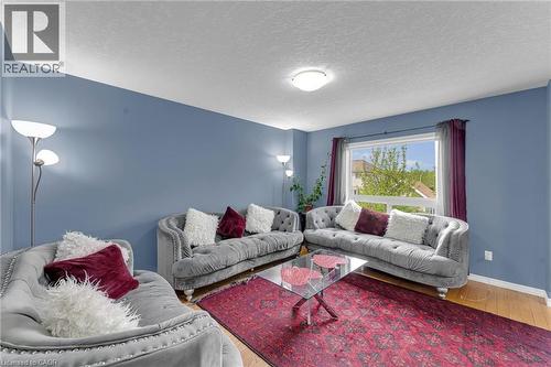 Living room featuring wood-finish flooring, a large window with exterior views, and a ceiling-mounted light fixture - 139 Ferris Drive, Wellesley, ON - Indoor Photo Showing Living Room