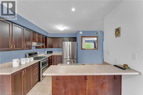 Kitchen featuring wood-finish cabinetry, stainless steel appliances, a gas range with double ovens, and tile flooring - 139 Ferris Drive, Wellesley, ON - Indoor Photo Showing Kitchen With Stainless Steel Kitchen