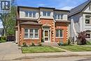 Brick facade home featuring a prominent front entrance, multiple windows, a paved driveway, a manicured lawn, and mature landscaping - 314 Hess Street S, Hamilton, ON  - Outdoor With Facade 