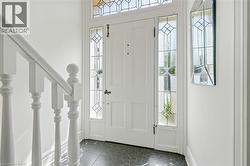 Entryway featuring a white paneled door with decorative leaded glass sidelights and transom window - 