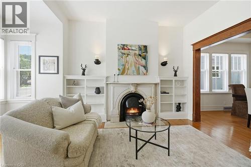 Living space featuring a detailed fireplace with a decorative mantel, flanked by built-in shelving - 314 Hess Street S, Hamilton, ON - Indoor Photo Showing Living Room With Fireplace