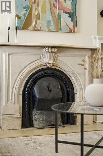 Ornate carved fireplace surround with a dark metal firebox insert - 314 Hess Street S, Hamilton, ON - Indoor