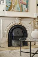 Ornate carved fireplace surround with a dark metal firebox insert - 