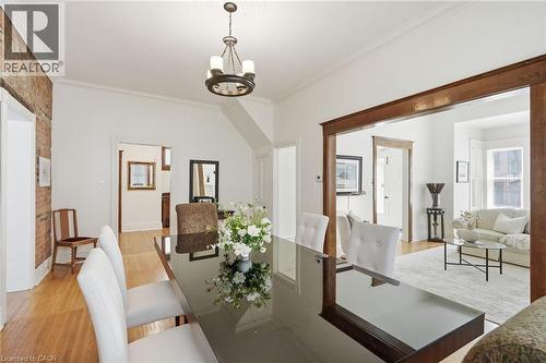Formal dining area featuring exposed brick, wood-finish flooring, and crown molding - 314 Hess Street S, Hamilton, ON - Indoor