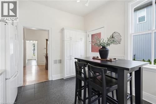 Kitchen area featuring dark-toned tile flooring, white cabinetry, and a large window - 314 Hess Street S, Hamilton, ON - Indoor