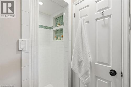 Shower featuring white subway tile surround, recessed lighting, and two built-in tile niches with green mosaic accents - 314 Hess Street S, Hamilton, ON - Indoor Photo Showing Bathroom