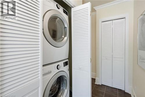 Stacked washer and dryer unit concealed behind louvered bifold doors - 314 Hess Street S, Hamilton, ON - Indoor Photo Showing Laundry Room
