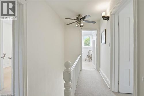 Upper-level hallway featuring light-colored carpeting, a ceiling fan with integrated lighting, white balusters, and paneled interior doors - 314 Hess Street S, Hamilton, ON - Indoor Photo Showing Other Room