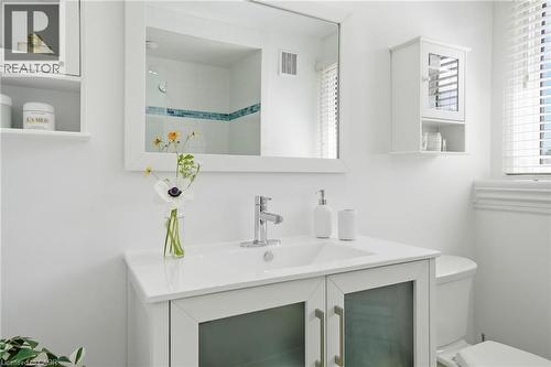 White vanity with an integrated sink and chrome faucet, framed by a large mirror - 314 Hess Street S, Hamilton, ON - Indoor Photo Showing Bathroom