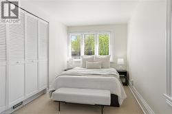 Bedroom featuring a multi-pane window with horizontal blinds, providing natural illumination - 