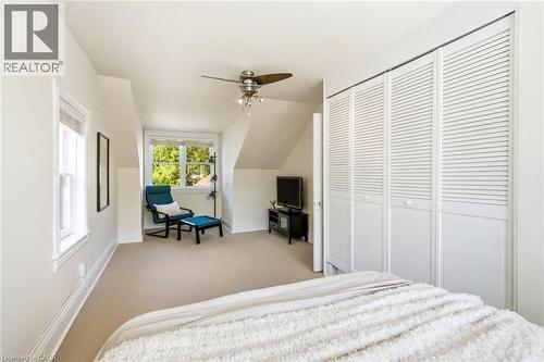 Carpeted room with a multi-pane window, sloped ceilings, and a ceiling fan with integrated lighting - 314 Hess Street S, Hamilton, ON - Indoor Photo Showing Bedroom