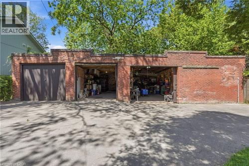 Brick garage structure featuring two bays, one with wood doors and the other open - 314 Hess Street S, Hamilton, ON - Outdoor