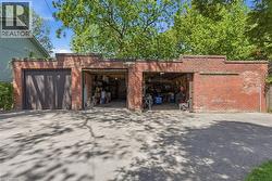 Brick garage structure featuring two bays, one with wood doors and the other open - 