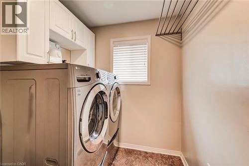 Dedicated laundry area featuring upper cabinetry, a window with blinds, and durable flooring - 702 Elgin Street N, Cambridge, ON - Indoor Photo Showing Laundry Room