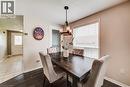 Dining area featuring wood-finish flooring, a contemporary chandelier, a large window with blinds, and neutral wall tones - 702 Elgin Street N, Cambridge, ON  - Indoor Photo Showing Dining Room 