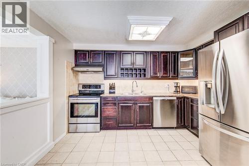 Kitchen featuring dark wood cabinetry, stone-finish countertops, and tile flooring - 702 Elgin Street N, Cambridge, ON - Indoor Photo Showing Kitchen