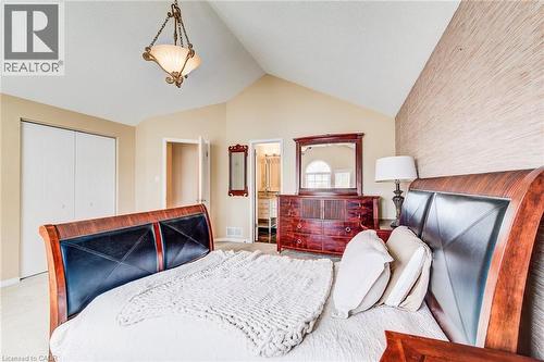 Vaulted ceiling bedroom featuring a textured accent wall, chandelier lighting, and double-door closet - 702 Elgin Street N, Cambridge, ON - Indoor Photo Showing Bedroom