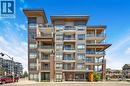 Modern multi-story building featuring multiple balconies, brick columns, and a prominent ""LAKEHOUSE"" sign above the entrance - 10 Esplanade Lane Unit# 310, Grimsby, ON  - Outdoor With Facade 