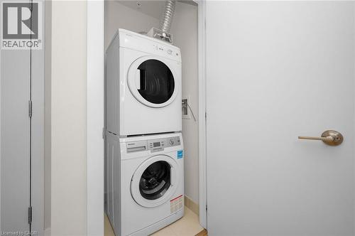 Convenient stackable washer and dryer unit within a dedicated utility space - 10 Esplanade Lane Unit# 310, Grimsby, ON - Indoor Photo Showing Laundry Room
